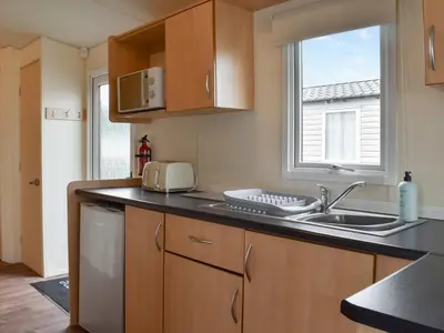a kitchen with a sink and a window at Sea Breeze in Heysham