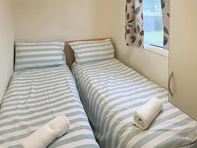 two beds sitting next to each other in a room at Sea Breeze in Heysham