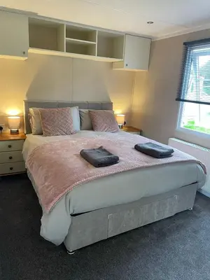 a bedroom with a large bed with two pillows on it at Lakes edge view in Millom
