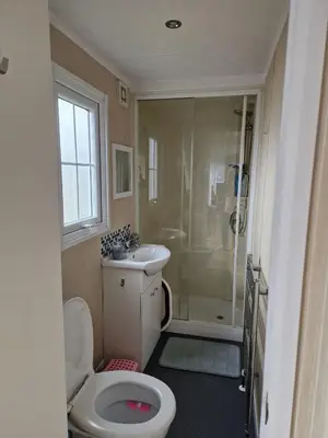 a bathroom with a toilet and a sink and a shower at Lakes edge view in Millom
