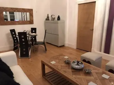 a living room with a coffee table and a dining room at The Paradise Suite in Southport