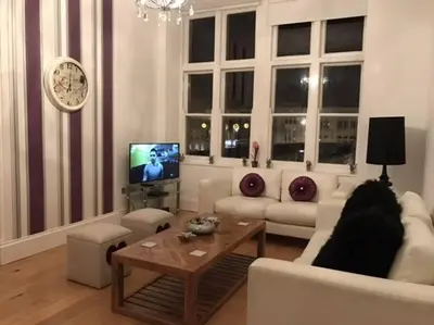 a living room with a white couch and a tv at The Paradise Suite in Southport