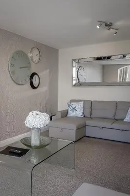a living room with a couch and clocks on the wall at The Place by Sasco - Free Parking in Blackpool