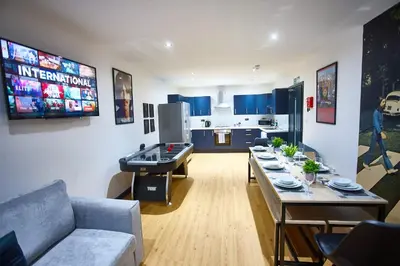 a living room with a ping pong table and blue cabinets at HARRISON SUITE 6 BEDS in Liverpool
