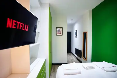 a room with a television and a bed with towels at HARRISON SUITE 6 BEDS in Liverpool