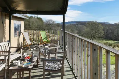 a wooden deck with chairs and a table on it at Curlew - Bleasdale in Chipping