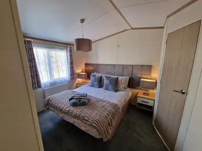 a bedroom with a bed with a bag on it at Ladybird Lodge in Carnforth