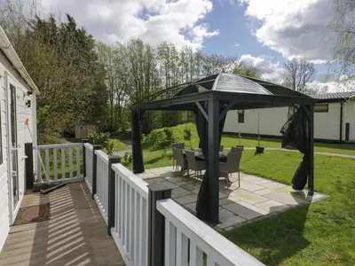 a gazebo with a table and chairs on a deck at Ladybird Lodge in Carnforth