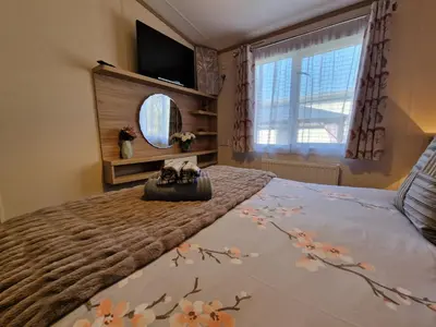 a bedroom with a bed with two cats sitting on it at Ladybird Lodge in Carnforth