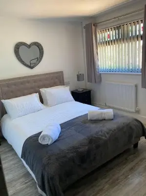 a bedroom with a large bed with two towels on it at Rockley Green House - 3 Bedroom Home in Liverpool in Liverpool