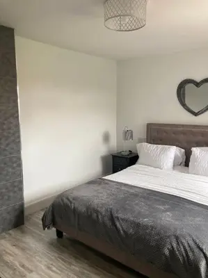 a bedroom with a bed with a heart on the wall at Rockley Green House - 3 Bedroom Home in Liverpool in Liverpool