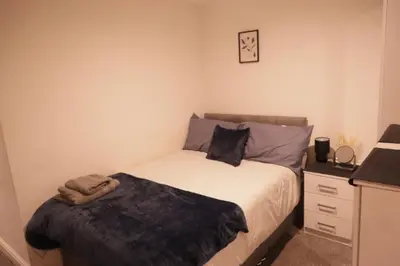 a small bedroom with a bed and a night stand at City Centre - Modern Apartment in Liverpool