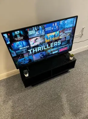 a flat screen tv sitting on a black stand at City Centre - Modern Apartment in Liverpool