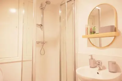 a bathroom with a shower and a sink and a mirror at City Centre - Modern Apartment in Liverpool