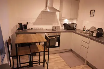 a small kitchen with a table and a stove at City Centre - Modern Apartment in Liverpool