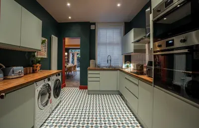 a kitchen with white cabinets and a washer and dryer at Luxury Seaside 5 Bed - 10 Mins Walk to Beaches in New Brighton