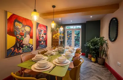 a dining room with a green table and chairs at Luxury Seaside 5 Bed - 10 Mins Walk to Beaches in New Brighton