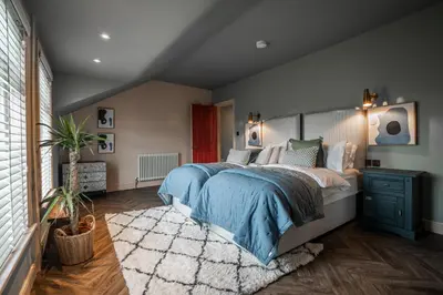 a bedroom with a large bed with a blue blanket at Luxury Seaside 5 Bed - 10 Mins Walk to Beaches in New Brighton