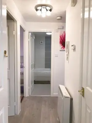 a hallway of a bathroom with a tub and a sink at Central Stylish 2Bedroom flat with free parking in Liverpool