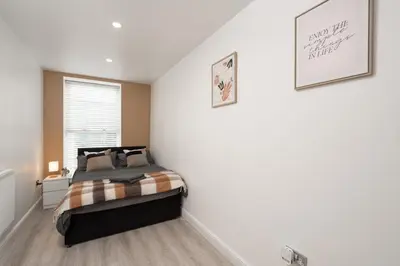 a bedroom with a bed and a white wall at Cosy central apartment - free nearby parking in Liverpool