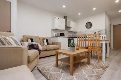 a living room with a couch and a table at Cosy central apartment - free nearby parking in Liverpool