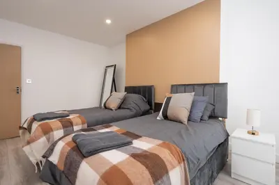 two beds sitting next to each other in a bedroom at Cosy central apartment - free nearby parking in Liverpool