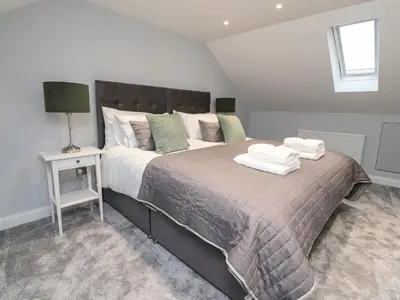 a bedroom with a large bed with towels on it at The bungalow at 46 Church St in Chorley