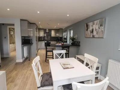 a kitchen and living room with a white table and chairs at The bungalow at 46 Church St in Chorley