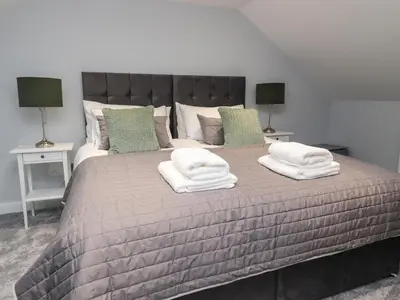 a bedroom with a large bed with three pillows on it at The bungalow at 46 Church St in Chorley