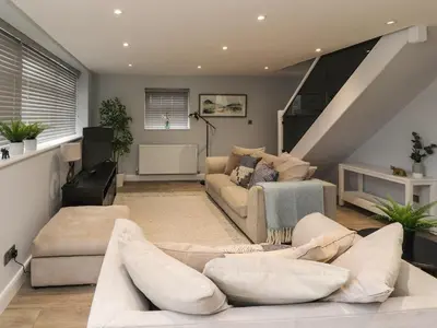 a living room with a couch and a staircase at The bungalow at 46 Church St in Chorley