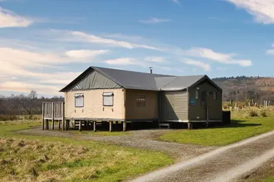 a small house with a black roof on a dirt road at Plover - Bleasdale in Chipping