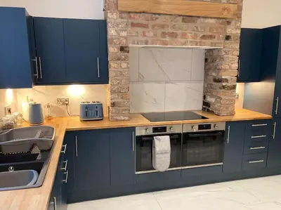 a kitchen with blue cabinets and a stove and a sink at Exceptional 5 bed house near City Centre in Liverpool