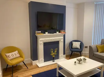 a living room with a fireplace with a tv above it at Exceptional 5 bed house near City Centre in Liverpool