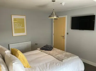 a room with a couch and a flat screen tv at Exceptional 5 bed house near City Centre in Liverpool