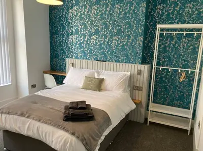 a bedroom with a bed with a backpack on it at Exceptional 5 bed house near City Centre in Liverpool