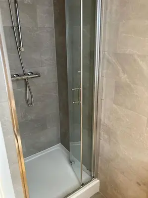 a shower with a glass door in a bathroom at Exceptional 5 bed house near City Centre in Liverpool