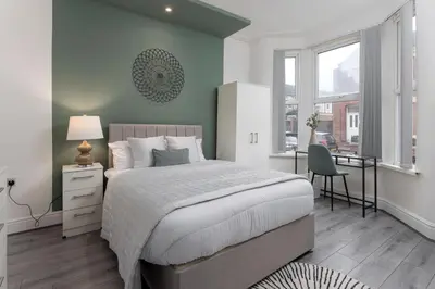 a bedroom with a bed and a desk and a window at Saxony House - Air Host & Stay - Free Parking in Liverpool