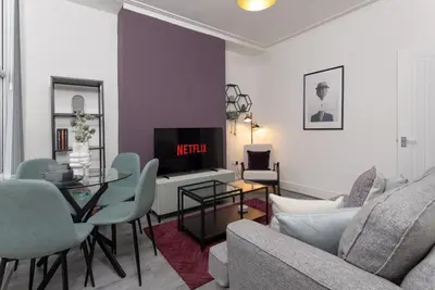 a living room with a couch a table and a tv at Saxony House - Air Host & Stay - Free Parking in Liverpool