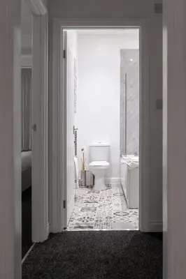 a white bathroom with a toilet and a sink at Saxony House - Air Host & Stay - Free Parking in Liverpool