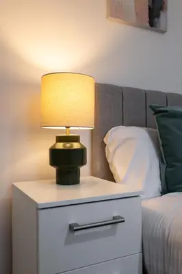 a lamp on a night stand next to a bed at Saxony House - Air Host & Stay - Free Parking in Liverpool