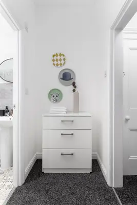 a white dresser in a room with white walls at Saxony House - Air Host & Stay - Free Parking in Liverpool