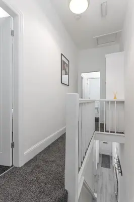 a white room with a staircase and a mirror at Saxony House - Air Host & Stay - Free Parking in Liverpool