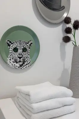 a mirror hanging on a wall next to a pile of towels at Saxony House - Air Host & Stay - Free Parking in Liverpool