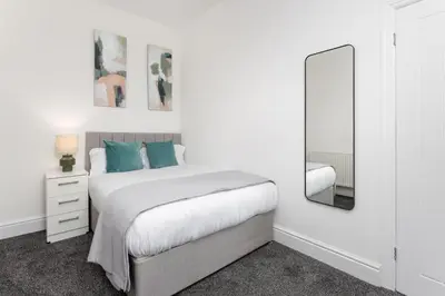 a white bedroom with a bed and a mirror at Saxony House - Air Host & Stay - Free Parking in Liverpool