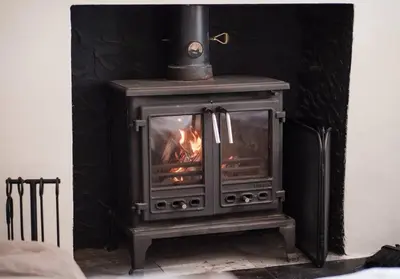 a wood stove with a fire in a room at Luxury Georgian Home, Nr the Lake District in Carnforth