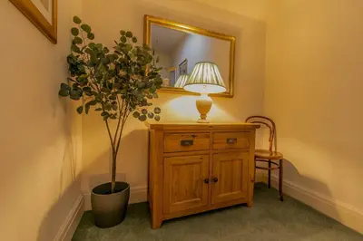 a table with a lamp and a plant in a room at 107a - 3 Double Bedrooms in Lytham St Annes