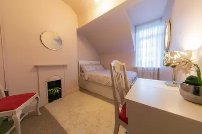 a small bedroom with a bed and a fireplace at 107a - 3 Double Bedrooms in Lytham St Annes