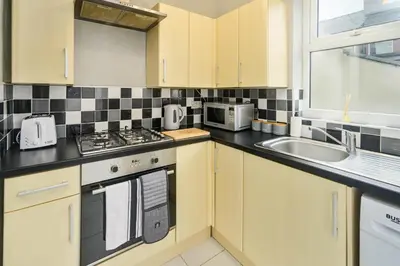 a kitchen with a stove and a sink at Willow House - 2-Bedroom House In Merseyside! in Birkenhead