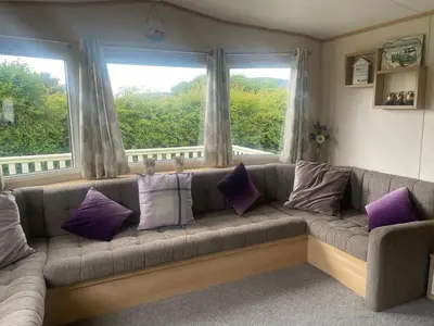 a living room with a couch with purple pillows at 147a Port Haverigg in Millom