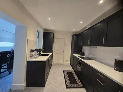 a kitchen with black cabinets and a white counter top at Lily in Blackpool